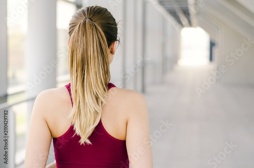 Young woman with ponytail concentrating before running indoors