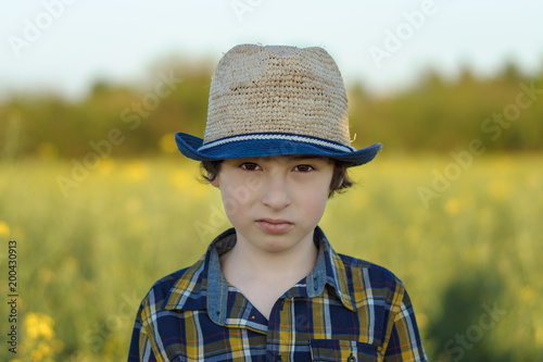 Portrait of a boy in a hat and shirt close-up.