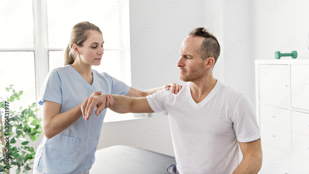 Obraz premium Patient at the physiotherapy doing physical exercises with his therapist