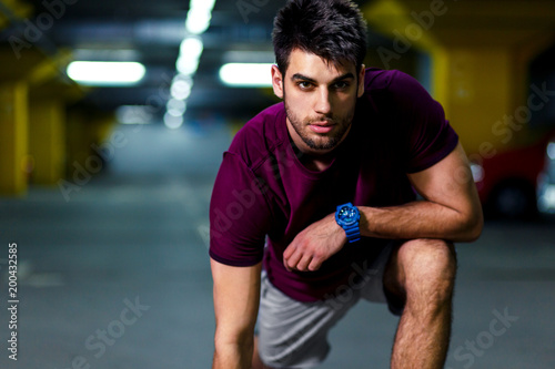  Young athlete man resting after workout in the underground car parking. © Zoran Zeremski