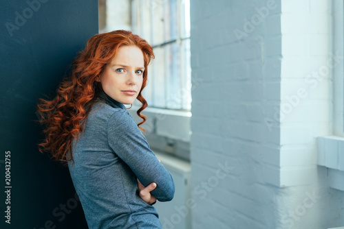 Thoughtful attractive redhead woman turning