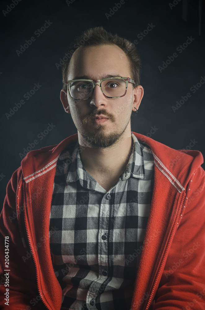 Fototapeta premium portrait of a guy in a plaid shirt with a beard. smokes electronic cigarettes. nicotine addiction
