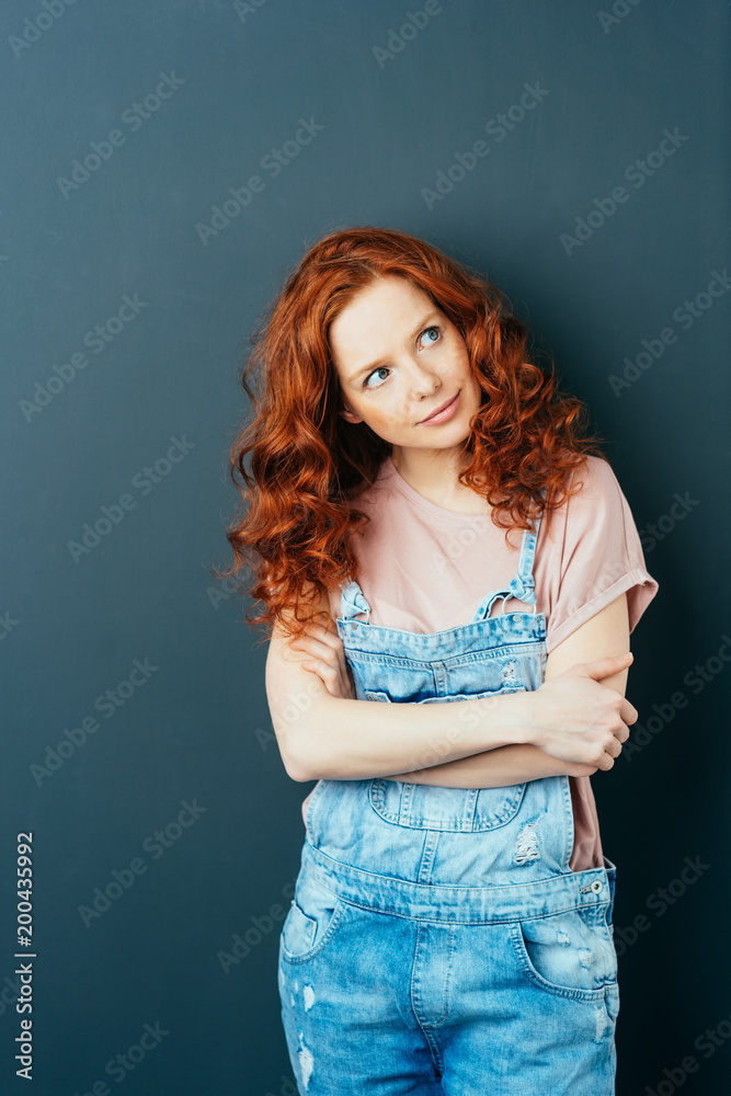 Pretty contented young woman standing thinking Pretty contented young woman standing thinking