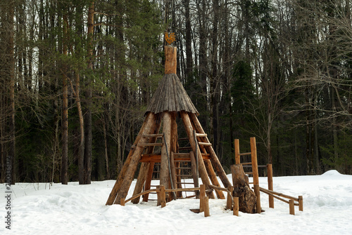 wooden structure on a children's playground in a winter forest park..