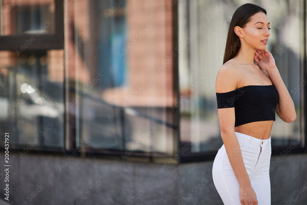 Beautiful sporty girl posing to camera on the street, spring time photo shoot