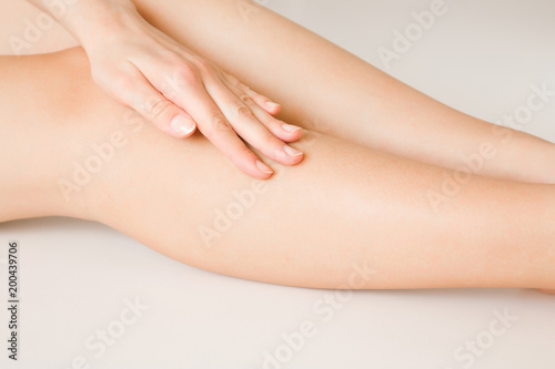 Beautiful  elegant woman s hands touching her legs. Cares about clean and soft legs skin after shaving or depilation. Healthcare concept.