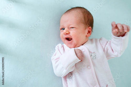 Cute two week old baby girl in cradle