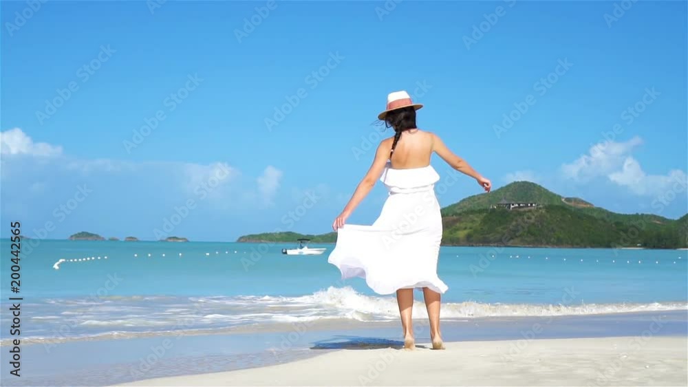 Young beautiful woman on white sand tropical beach.