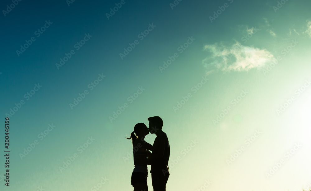 Silhouette of man and woman kissing. 