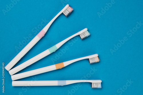 Toothbrushes on empty blue background  top view. Dental equipment  oral health care concept.