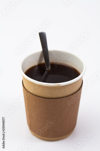  Black coffee in a cardboard throwaway coffee cup with spoon on white 