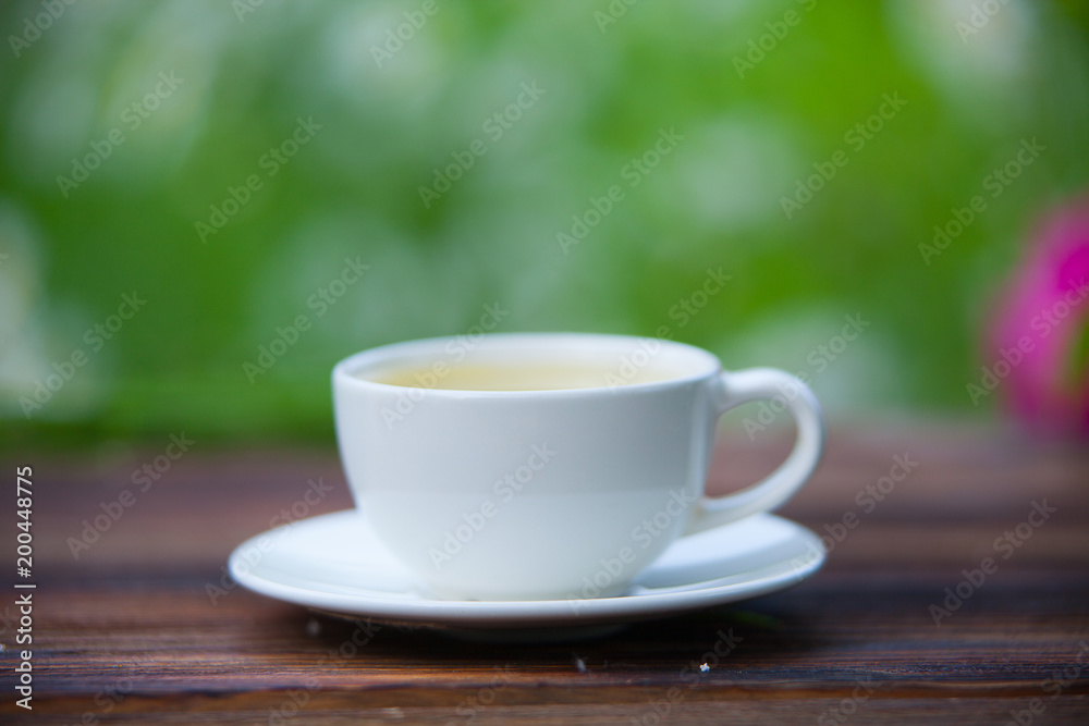 porcelainl cup with green tea on table porcelainl cup with green tea on table