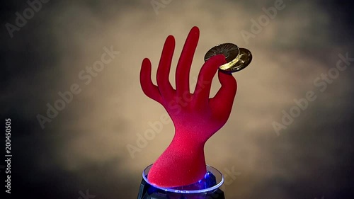  пальцы держат монета биткоин, крутящаяся красная кисть руки с криптовалютой