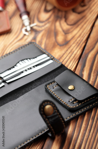 Black leather wallet.Genuine leather craft object with tool using for wallet.Hand crafted wallet.Closeup