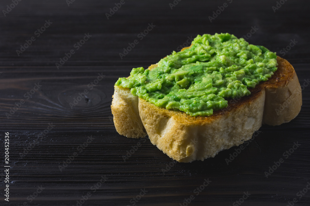 Toast with smashed avocado and lime on brown wooden background Toast with smashed avocado and lime on brown wooden background