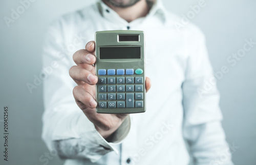 Caucasian businessman showing calculator.