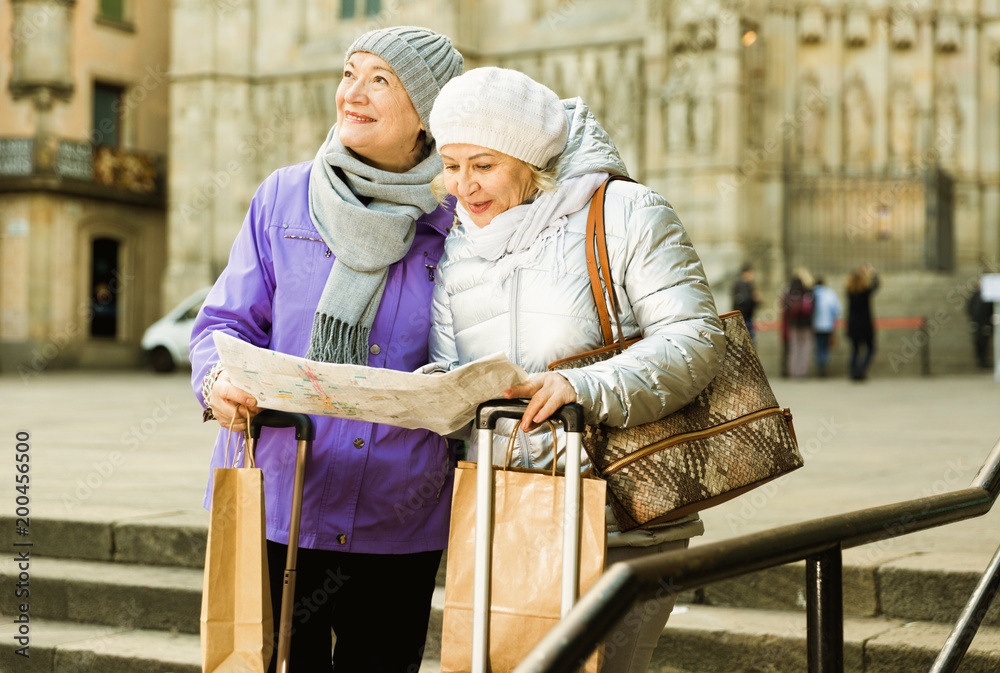 Senior females traveling with city map