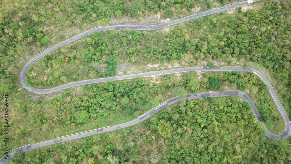 Top view. Aerial view from drone. Royalty high quality free stock image of road in forest. Road in forest is beautiful with many tree, road on pass very winding and curve Top view. Aerial view from drone. Royalty high quality free stock image of road in forest. Road in forest is beautiful with many tree, road on pass very winding and curve