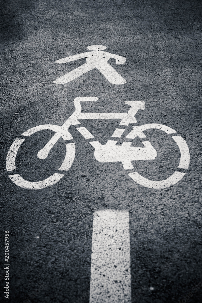 Pedestrian and cycle lane sign or symbol painted on asphalt. Black and white. Pedestrian and cycle lane sign or symbol painted on asphalt. Black and white.