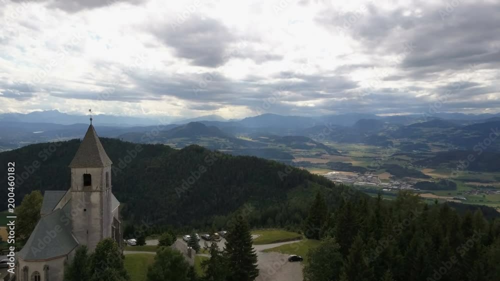 Flight above Ancient church on a mountain. AERIAL view of Magdalensberg, Carinthia, Austria. Beautiful mountains on horizon. Flight above Ancient church on a mountain. AERIAL view of Magdalensberg, Carinthia, Austria. Beautiful mountains on horizon.