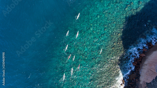 Aerial shots of people kayaking on a tropical island.