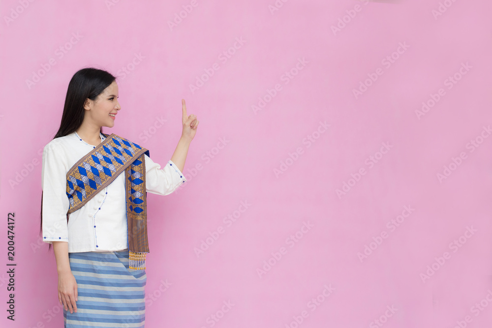 Portrait beautiful Asian girl in traditional Thai dress isolated on pink background. .Cotton Dress Portrait beautiful Asian girl in traditional Thai dress isolated on pink background. .Cotton Dress