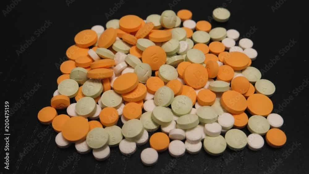 Spilled medication pills on a table. Camera turning around the subject. Spilled medication pills on a table. Camera turning around the subject.