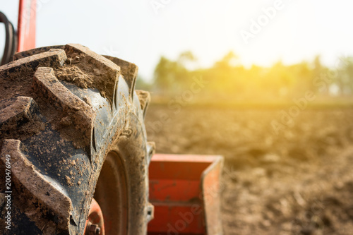Tractor tire on field. Agriculture Tractor plowing field.