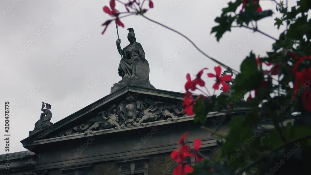 A statue of a warrior and dragons on a roof of a medieval building. A statue of a warrior and dragons on a roof of a medieval building.