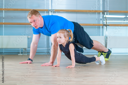 Group of children doing kids gymnastics in gym with teacher. Happy sporty children in gym. bar exercise. plank.