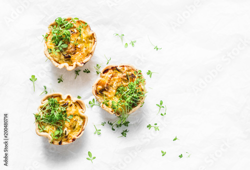 Fotografía Mini savory pie with chicken, leek, cheese on light background, top view