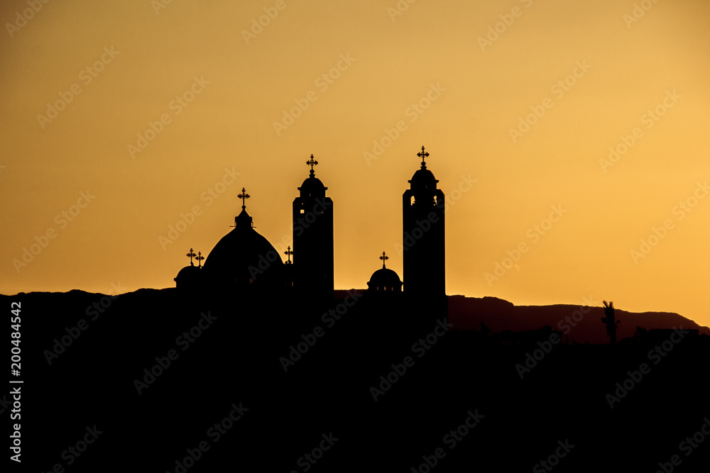 silhouette of the Coptic church on sunset background