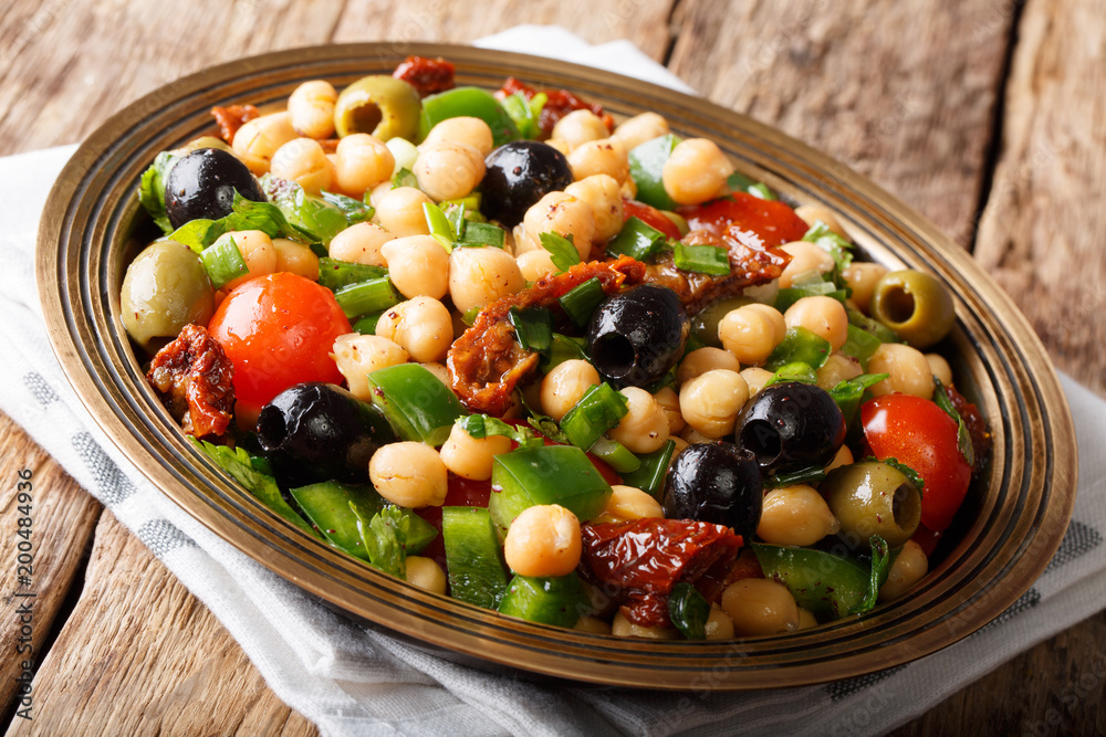 East balela salad with chickpeas, tomatoes, onions, olives and herbs closeup. horizontal, rustic