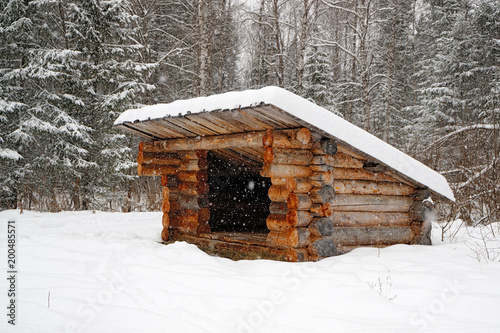a refuge for partisans in the forest in winter, a structure of logs with a roof photo