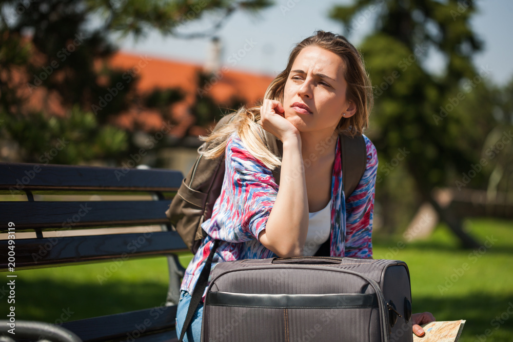 Young woman is going on vacation. She is waiting for her transportation. Young woman is going on vacation. She is waiting for her transportation.