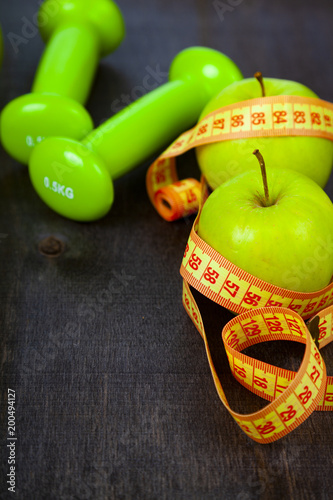 Apple,dumbbells and measuring tape