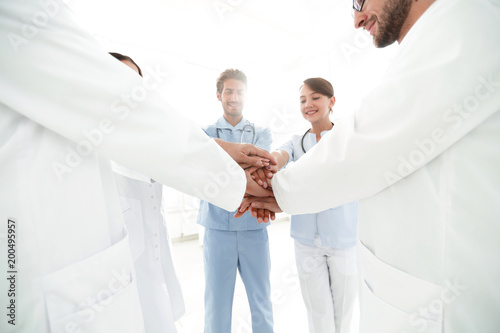 Doctors and nurses in a medical team stacking hands