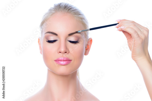 Junge Frau beim Auftragen von Make-up, Kosmetik, Schönheit, Beauty, Makeup, Gesicht; Nahaufnahme