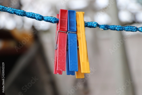 Three pegs hunging on blue twine and waiting for a clothes photo