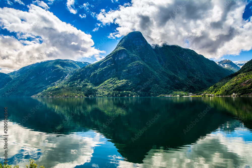 Norway landscapes. The mountains are reflecting in the water of the fjord on a sunny day Norway landscapes. The mountains are reflecting in the water of the fjord on a sunny day