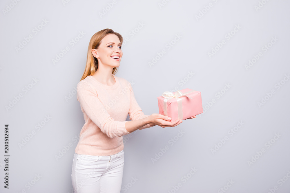 Chill rest relax amazement wonderment people tradition seasonal person concept. Half-turned portrait of pretty lady giving giftbox wearing white pants sweater isolated on gray background copyspace Chill rest relax amazement wonderment people tradition seasonal person concept. Half-turned portrait of pretty lady giving giftbox wearing white pants sweater isolated on gray background copyspace