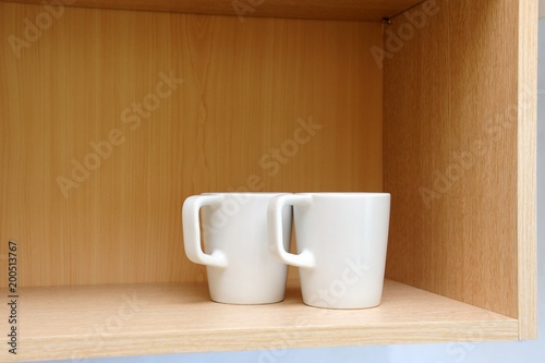 Kitchen cupboard with white cups. Live at home with my husband and wife. live together. Scandinavian style