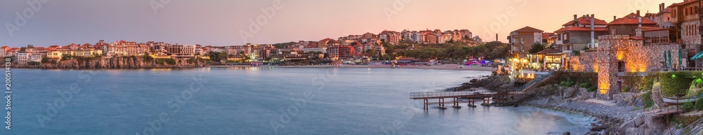 Seaside landscape, panorama, banner - view of the embankment with fortress wall during sunset in the city of Sozopol on the Black Sea coast in Bulgaria.