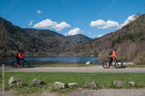  panorama of lake of Kruth with beautiful cloudy sky and mountain bike couple
