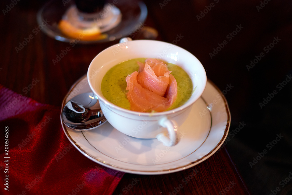 Cream soup with broccoli and salmon on wooden table Cream soup with broccoli and salmon on wooden table