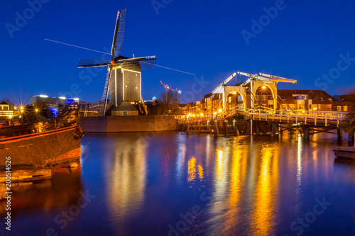 Cityscape - evening view of the city canal with drawbridge and windmill, the city of Leiden, Netherlands.