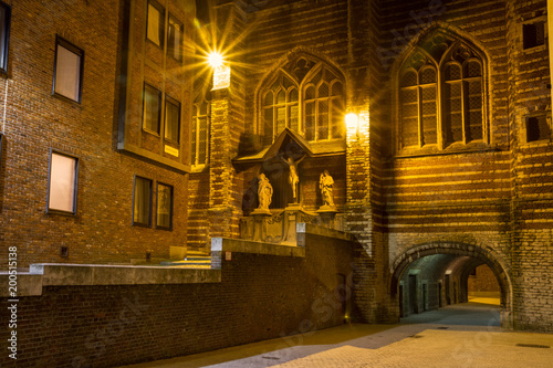 Evening cityscape - view of The Vleeshuis (Butchers Hall, or literally Meat House) and sculptural group referring to the theme of Calvary (Christ, Mary, John), in Antwerp, Belgium photo