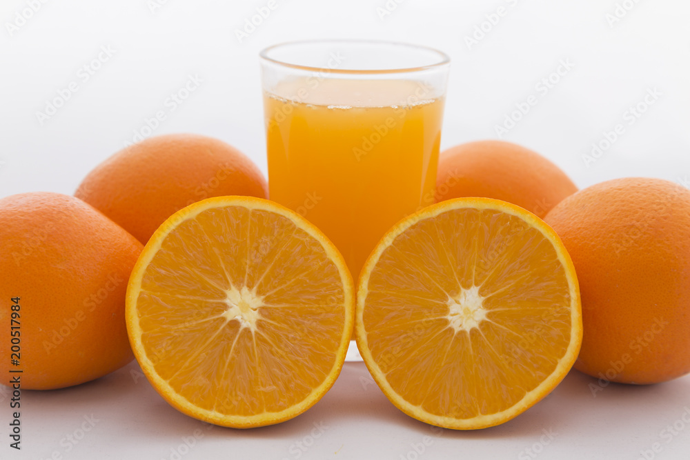 Orange cut on white background and orange juice in glass Orange cut on white background and orange juice in glass