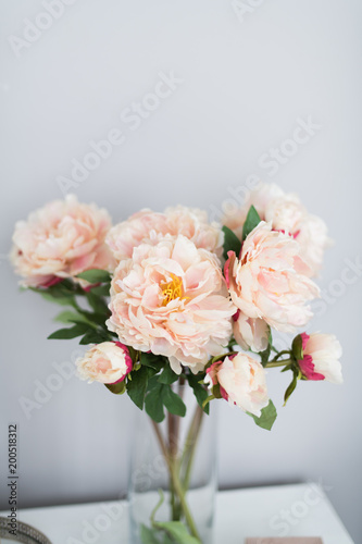 A bouquet of decorative peonies stands on a gray background. Vertical photo © borislav15