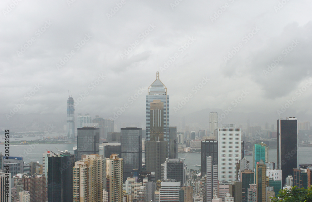 Hong Kong: View from Stubbs Road Lookout across Wan Chai to Tsim Sha Tsui with a large construction site on a rainy summer day